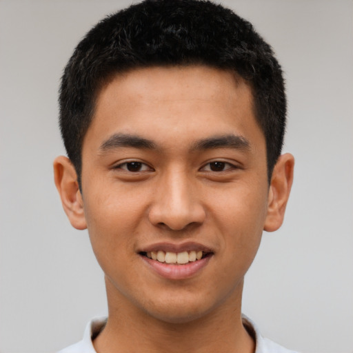 Joyful latino young-adult male with short  black hair and brown eyes
