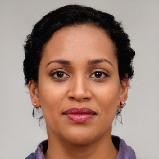 Joyful black young-adult female with long  brown hair and brown eyes