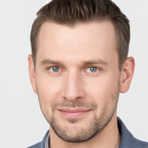 Joyful white young-adult male with short  brown hair and grey eyes