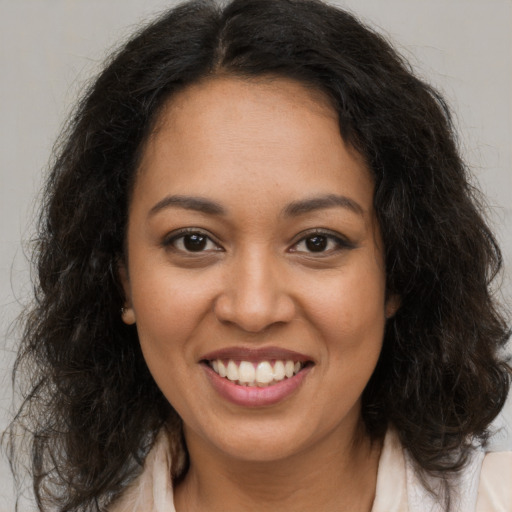 Joyful latino young-adult female with long  brown hair and brown eyes