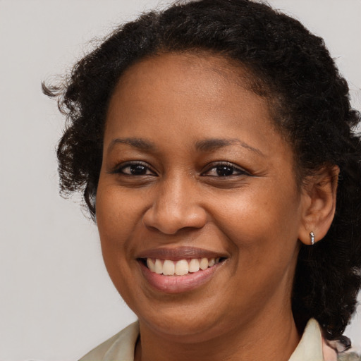 Joyful black young-adult female with medium  brown hair and brown eyes