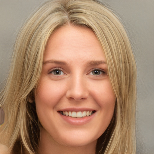 Joyful white young-adult female with long  blond hair and brown eyes