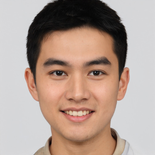 Joyful asian young-adult male with short  brown hair and brown eyes