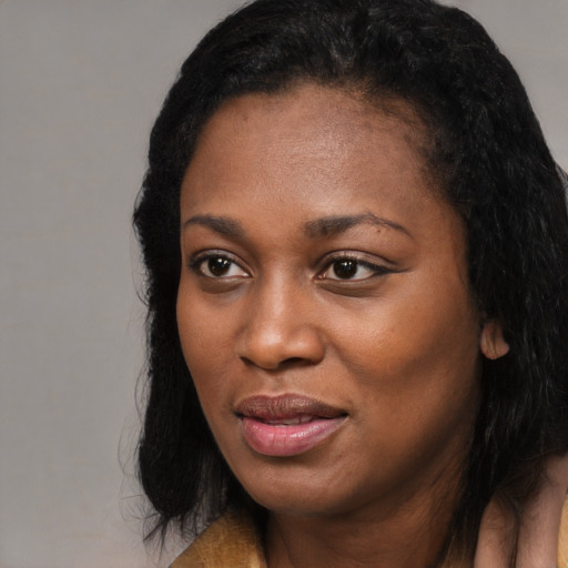 Joyful black young-adult female with long  black hair and brown eyes