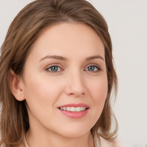 Joyful white young-adult female with long  brown hair and grey eyes