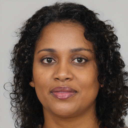 Joyful black young-adult female with medium  brown hair and brown eyes
