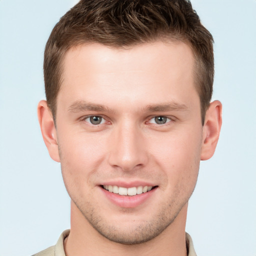 Joyful white young-adult male with short  brown hair and grey eyes