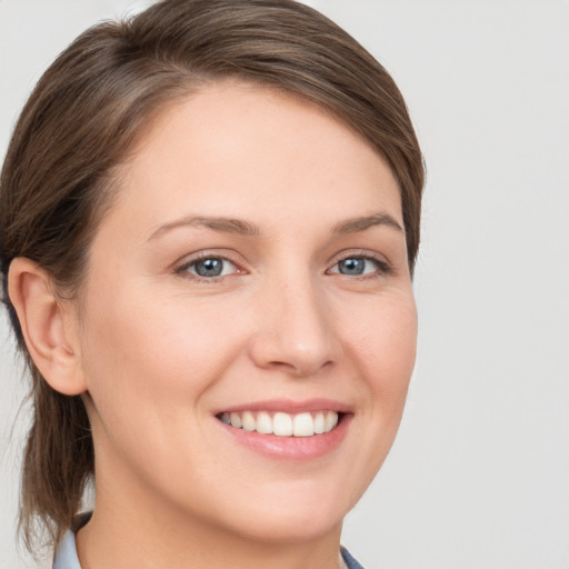 Joyful white young-adult female with short  brown hair and grey eyes