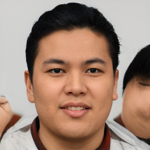 Joyful asian young-adult male with short  brown hair and brown eyes