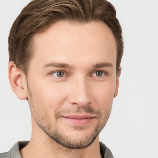 Joyful white young-adult male with short  brown hair and grey eyes