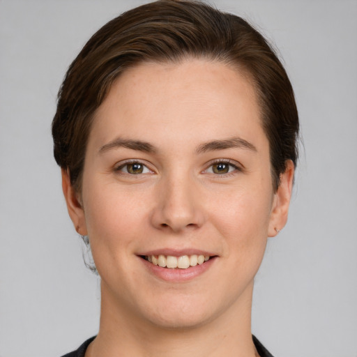 Joyful white young-adult female with short  brown hair and grey eyes