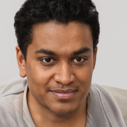 Joyful black young-adult male with short  brown hair and brown eyes