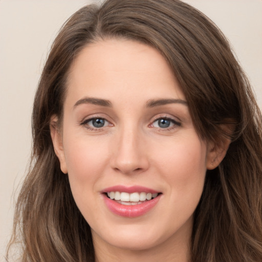 Joyful white young-adult female with long  brown hair and grey eyes