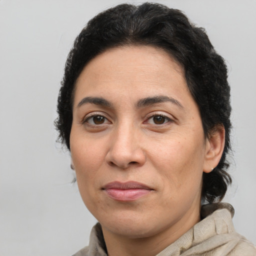 Joyful latino adult female with medium  brown hair and brown eyes