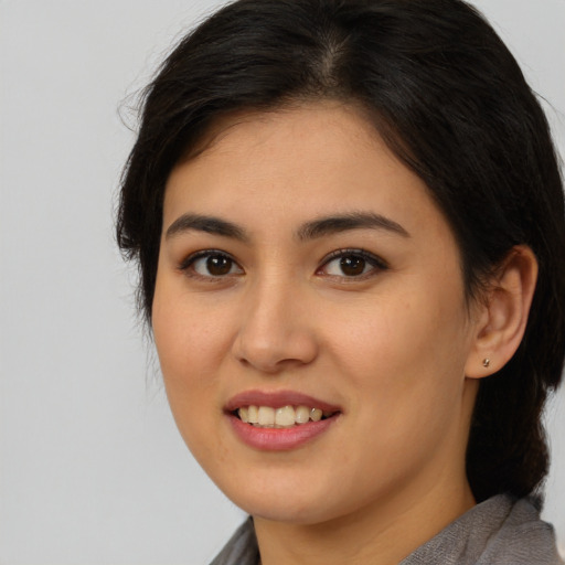 Joyful latino young-adult female with medium  brown hair and brown eyes