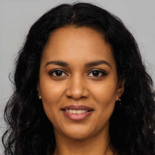 Joyful black young-adult female with long  black hair and brown eyes
