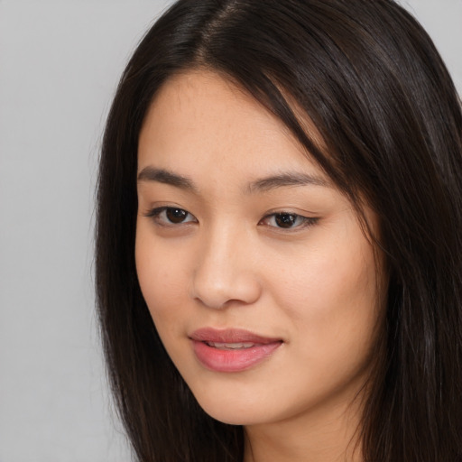 Joyful asian young-adult female with long  brown hair and brown eyes