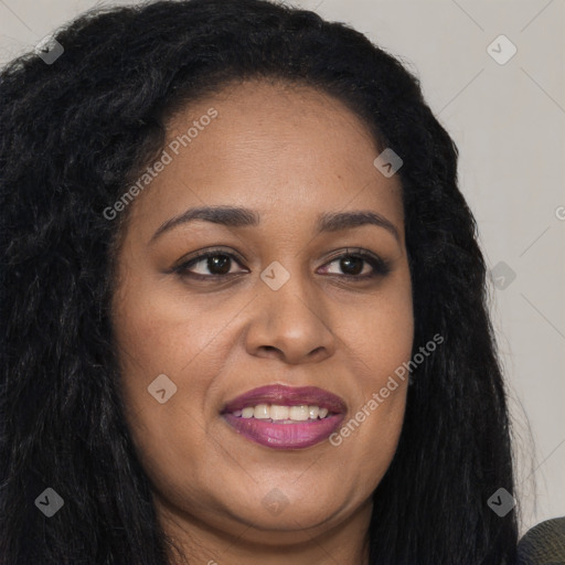 Joyful black young-adult female with long  brown hair and brown eyes