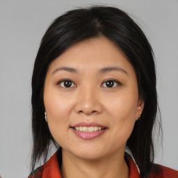 Joyful asian young-adult female with medium  brown hair and brown eyes