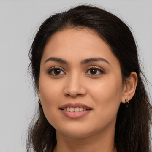 Joyful latino young-adult female with long  brown hair and brown eyes