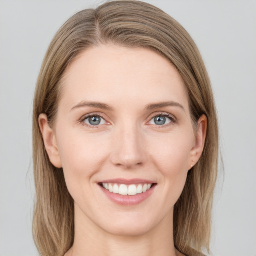 Joyful white young-adult female with medium  brown hair and grey eyes