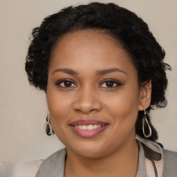 Joyful black young-adult female with long  brown hair and brown eyes