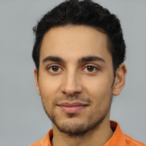 Joyful latino young-adult male with short  black hair and brown eyes