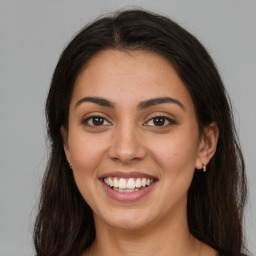 Joyful latino young-adult female with long  brown hair and brown eyes