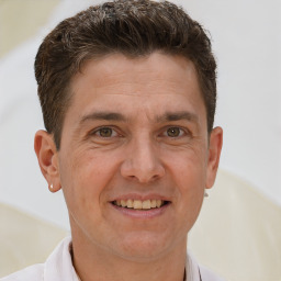 Joyful white adult male with short  brown hair and brown eyes