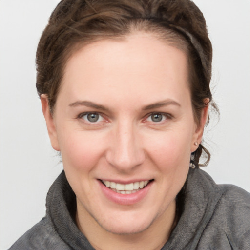 Joyful white young-adult female with short  brown hair and grey eyes