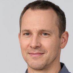 Joyful white adult male with short  brown hair and brown eyes