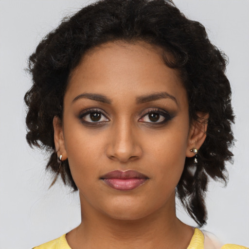 Joyful black young-adult female with medium  black hair and brown eyes