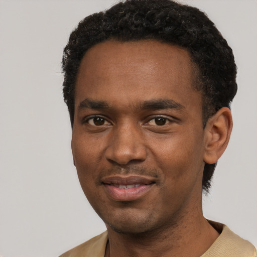 Joyful black young-adult male with short  black hair and brown eyes