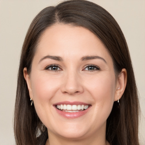 Joyful white young-adult female with long  brown hair and brown eyes