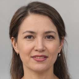 Joyful white adult female with long  brown hair and brown eyes