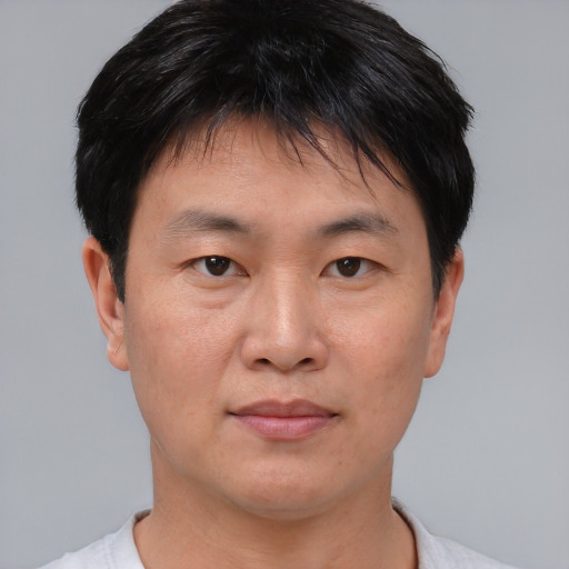 Joyful asian adult male with short  brown hair and brown eyes