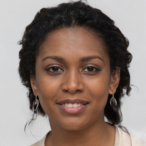 Joyful black young-adult female with long  brown hair and brown eyes
