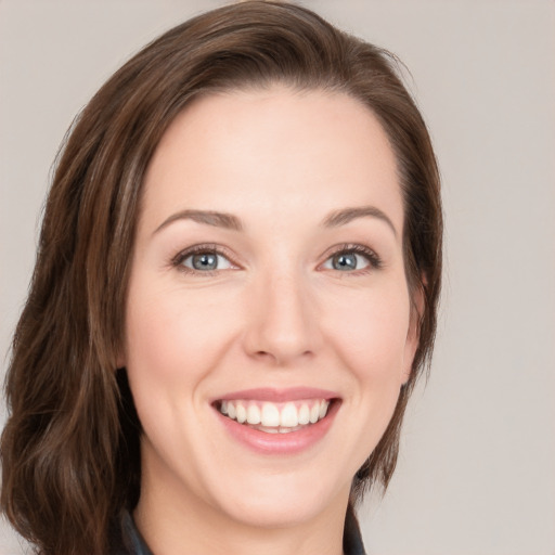 Joyful white young-adult female with medium  brown hair and blue eyes