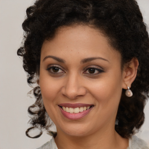 Joyful black young-adult female with medium  brown hair and brown eyes