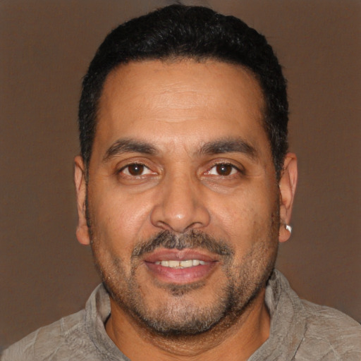 Joyful black adult male with short  black hair and brown eyes