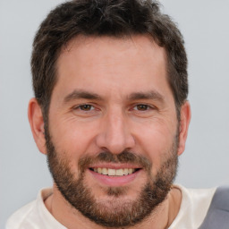 Joyful white adult male with short  brown hair and brown eyes