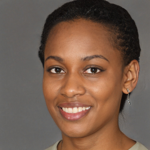Joyful black young-adult female with short  brown hair and brown eyes