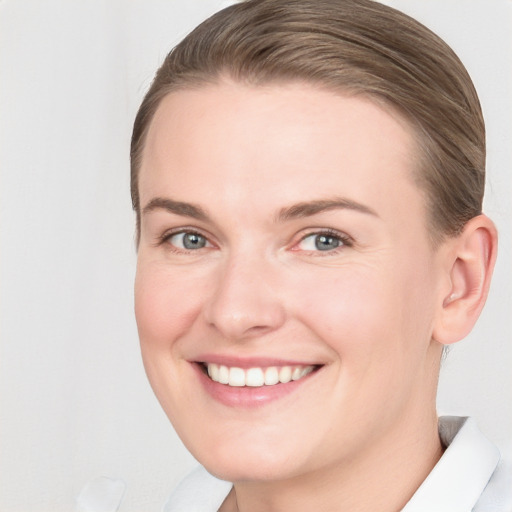 Joyful white young-adult female with short  brown hair and grey eyes