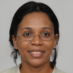 Joyful black adult female with medium  brown hair and brown eyes