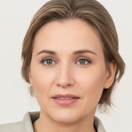 Joyful white young-adult female with medium  brown hair and grey eyes