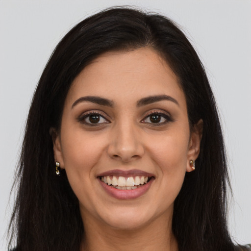 Joyful latino young-adult female with long  brown hair and brown eyes