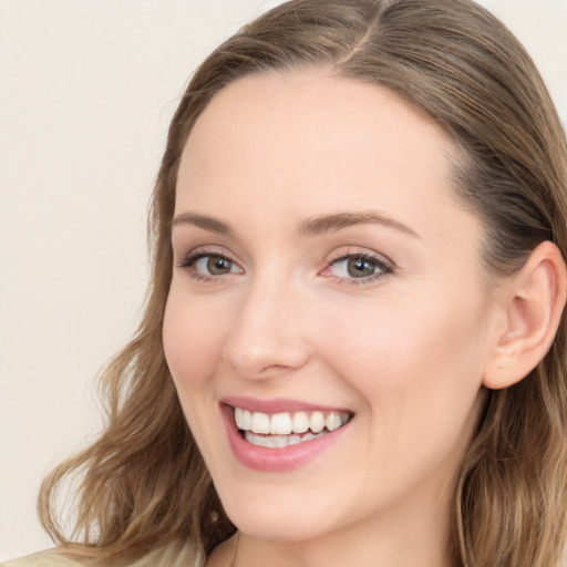 Joyful white young-adult female with long  brown hair and blue eyes