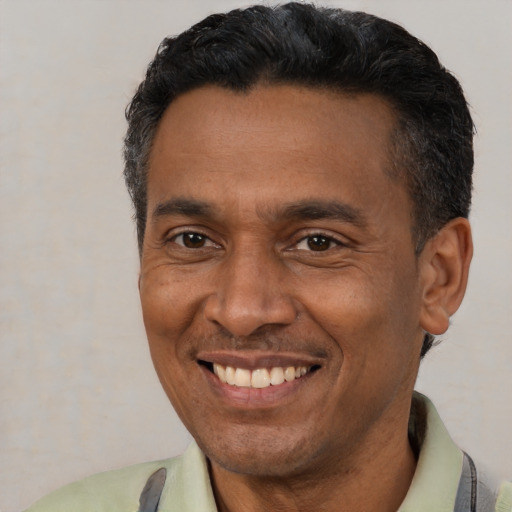 Joyful latino adult male with short  black hair and brown eyes