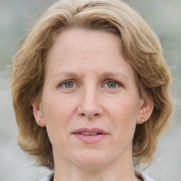 Joyful white adult female with medium  brown hair and blue eyes