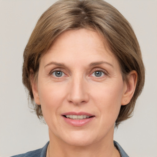 Joyful white adult female with medium  brown hair and grey eyes